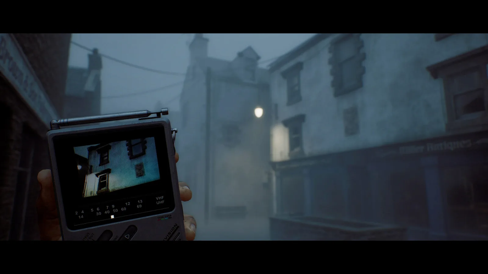 Silent Hill: Townfall : la télévision portable tenue en main dans une rue brumeuse